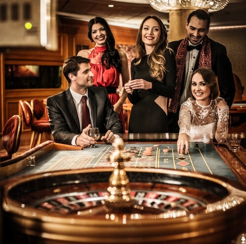 An image of Group of young people behind roulette table in a casino