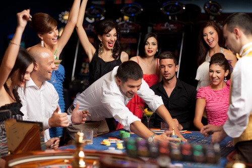 An image of an adult group celebrating friend winning at roulette