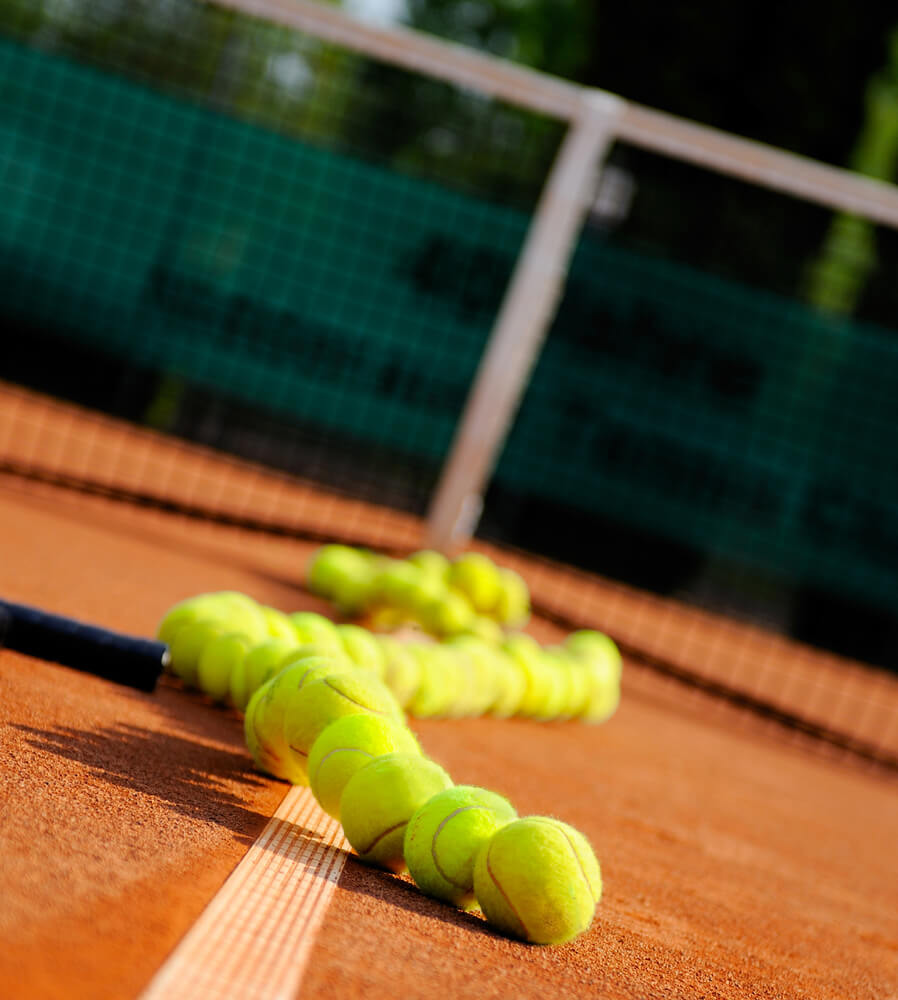 An image of tennis balls on the clay surface of the french open